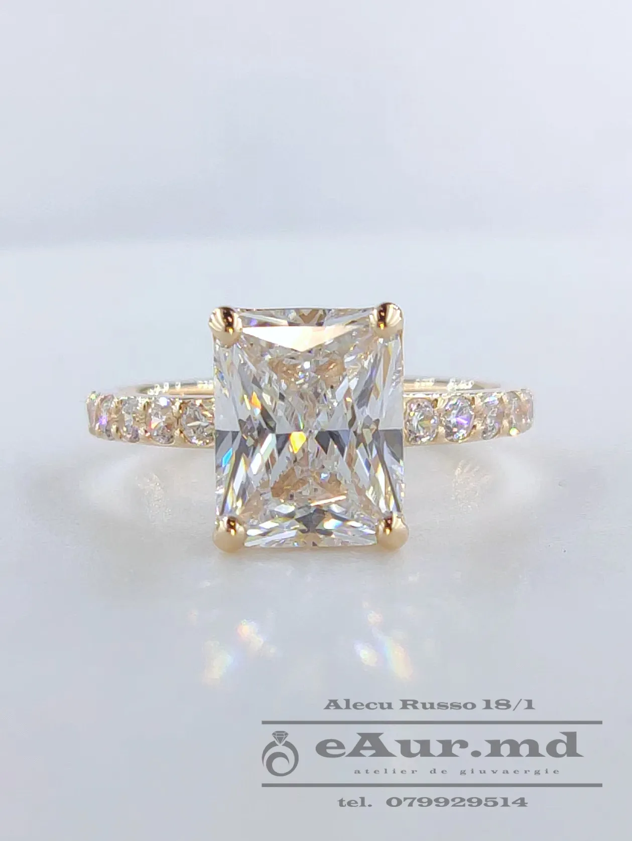 inel de logodna cu piatra dreptunghiulara incolora si pietre mici rotunde prin parti creat in atelierul de bijuterii eAur.md din chisinau